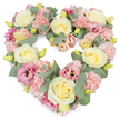 A tender heart-shaped funeral wreath of pastel flowers is displayed against a bright white background, its contours clearly defined yet softened by an abundance of petals and leaves. The entire heart is densely covered in blooms so that it appears full and generous, like a floral embrace. Cream-toned and pale yellow roses take pride of place, spaced evenly across the design, their tightly spiralled centres and velvety petals giving a sense of quiet strength and enduring love. Around them, light pink carnations add volume and a delicate, ruffled texture, their frilled edges overlapping to create a gentle, cloud-like effect. Deeper rose-pink and mauve lisianthus blooms are tucked among the pastels, their open, trumpet-like shapes adding subtle drama and pockets of richer colour, much like the shifting hues over Peckham's rooftops at dusk. Silvery-green eucalyptus leaves weave throughout the composition, their smooth, rounded foliage introducing a cool, restful tone and naturally framing the heart's curves. Tiny yellow-green buds appear here and there, catching the light and suggesting freshness and the possibility of new beginnings. The overall impression is serene and compassionate, making this heart a fitting tribute for a funeral, graveside farewell, or memorial service in the Peckham area. It is easy to imagine this wreath resting beside a casket or displayed near the front of a chapel, silently expressing love, memory, and gratitude for a life well lived. Crafted with the sensitivity of an experienced Peckham florist, it allows flowers to carry emotions that are sometimes too deep for words.